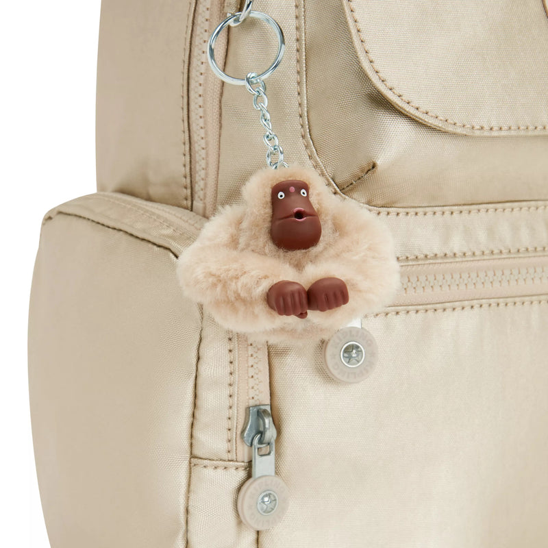 Fluffy monkey keychain attached to a beige bag