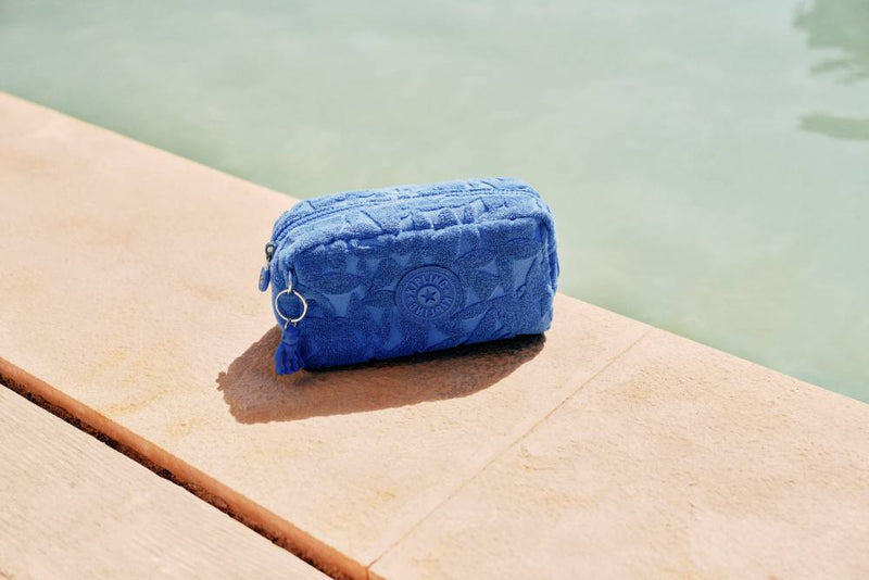 Blue towel with floral pattern on a wooden surface by a body of water