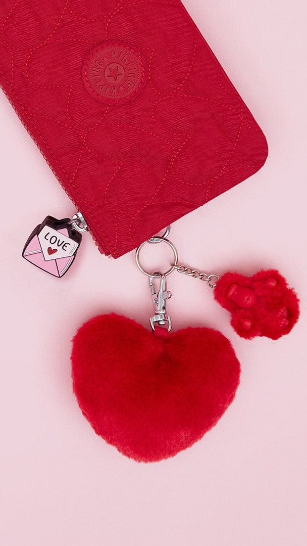 Red heart-shaped keychain with a pink background